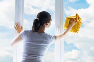 Young woman washing windows